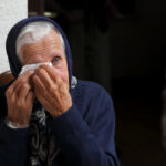 Grandmother crying and wiping tears with handkerchief